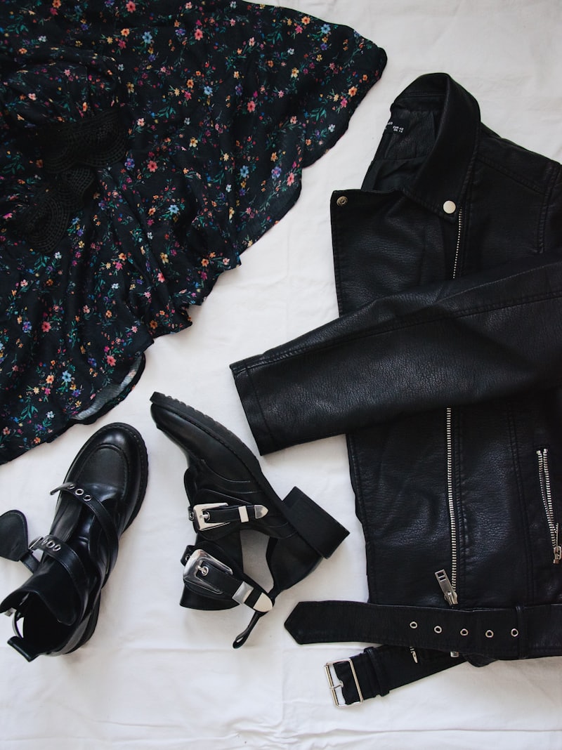 Black leather rider jacket laid flat with boots and belt